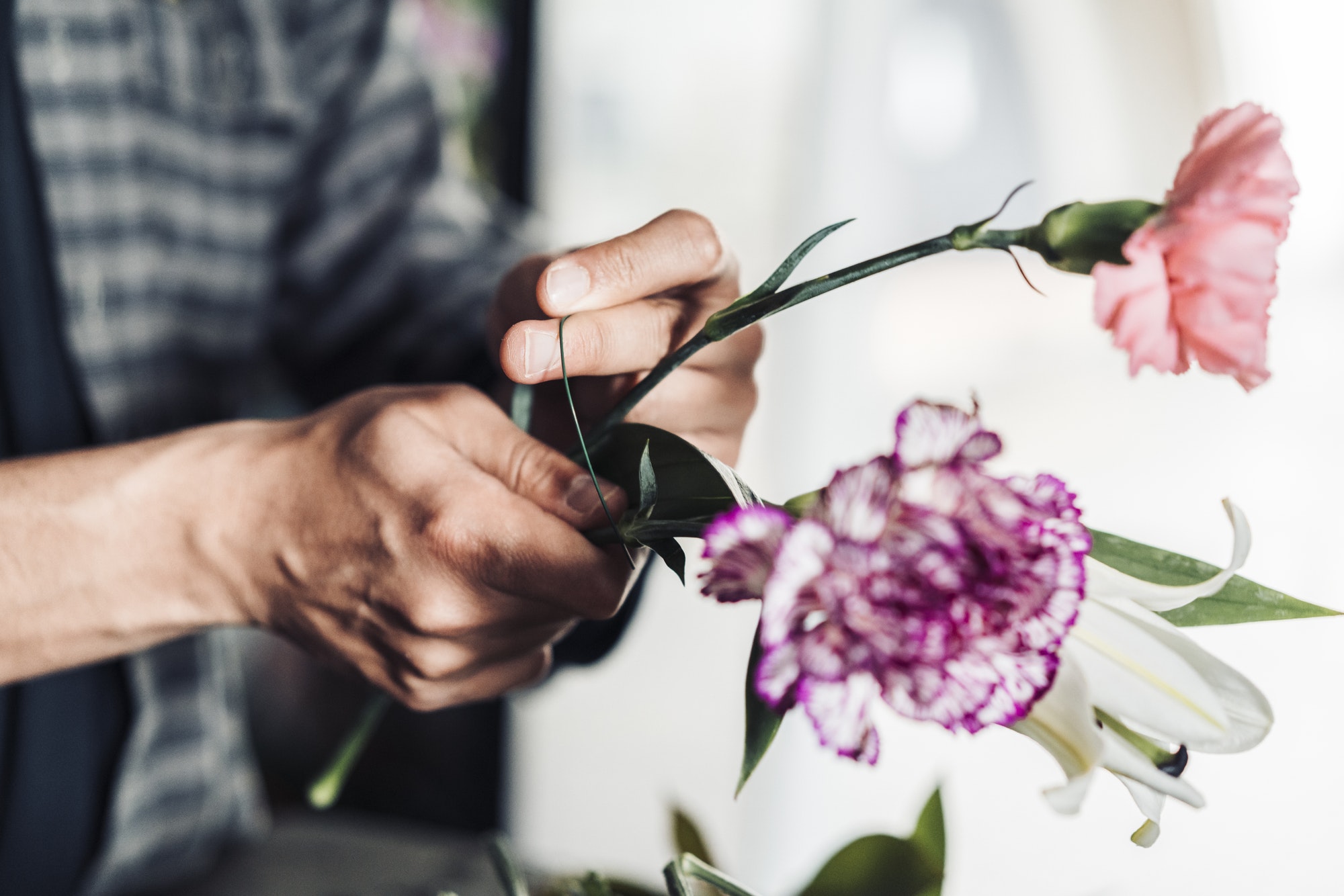 Young male florist working in flower shop