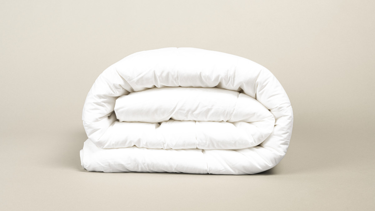 une couette pliée sur un fond beige